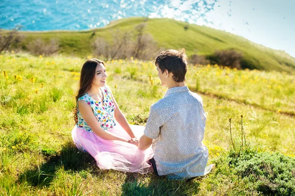 Feliz joven pareja cogida de la mano y riendo en la playa — Foto de Stock