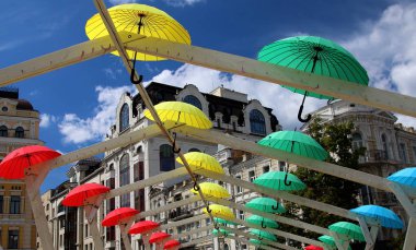 Gökyüzü ve şehir manzarasına karşı çeşitli şemsiyeler