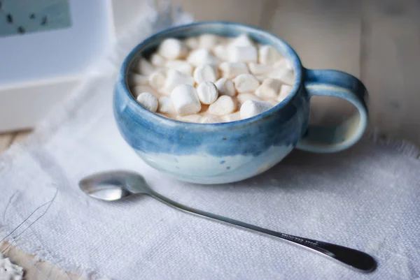 Una taza de cacao con marshmellows y decoración navideña en la mesa con fondo colorido. Fondo de vacaciones de Navidad. Phantom Blue . — Foto de Stock