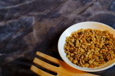 Kepekli Yulaf ve Kurutulmuş Çilek ile mısır gevreği kahvaltısı. Kahvaltı için lezzetli ve mükemmel, sağlıklı bir aperatif, egzersiz yemeği ya da dondurma malzemesi olarak. Üst manzara, düz uzanma.