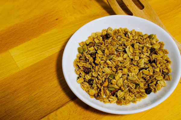 Kepekli Yulaf ve Kurutulmuş Çilek ile mısır gevreği kahvaltısı. Kahvaltı için lezzetli ve mükemmel, sağlıklı bir aperatif, egzersiz yemeği ya da dondurma malzemesi olarak. Üst manzara, düz uzanma.