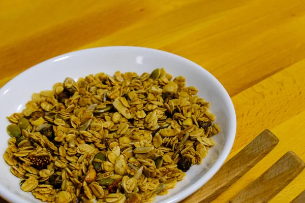 Kepekli Yulaf ve Kurutulmuş Çilek ile mısır gevreği kahvaltısı. Kahvaltı için lezzetli ve mükemmel, sağlıklı bir aperatif, egzersiz yemeği ya da dondurma malzemesi olarak. Üst manzara, düz uzanma.