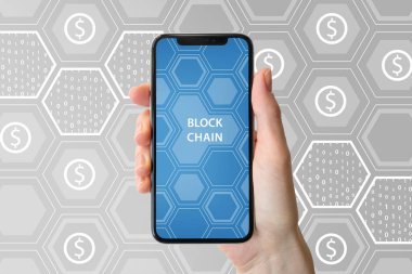 Blockchain ve cryptocurrency kavramı. Modern çerçeve ücretsiz smartphone tarafsız arka plan önünde tutan el.