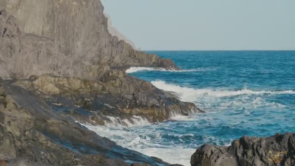 Ocean, blå vattenvågor kraschar på vulkaniska bergarter — Stockvideo