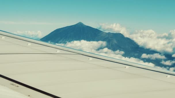 Traveling by air. View of volcano through an airplane window. — Stock Video