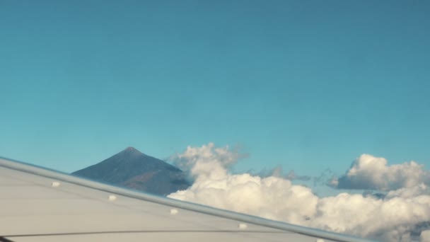 Traveling by air. View of volcano through an airplane window. — Stock Video