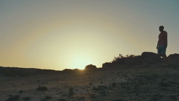 Uomini che camminano lungo la collina. Silhouette del tramonto. Rallentatore . — Video Stock