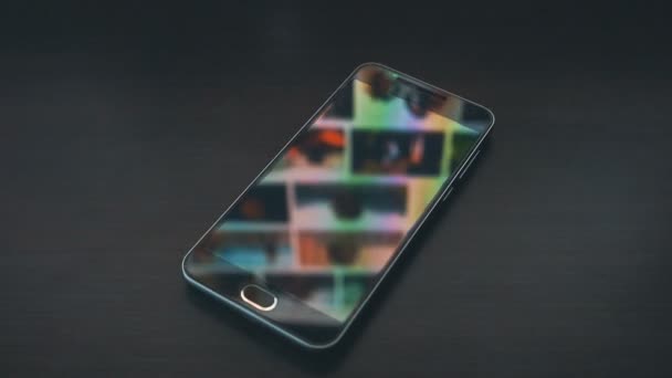 Smartphone with scrolling gallery page monitor reflections on the background. Up sliding. — Stock Video