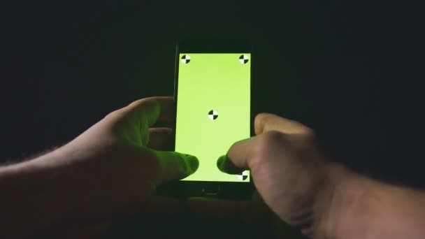 Closeup of young man hands typing sms scrolling pictures phone. Night. Green screen. Chroma key. — Stock Video