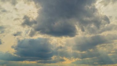 Beyaz bulutlar güneş ışınları ile mavi gökyüzü üzerinde uçan. Güneş ışınları. Zaman atlamalı.