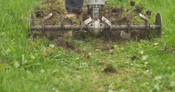 Close-up van hand motor opzijschuiven mes gooien grond en gras. Bewolkt — Stockvideo