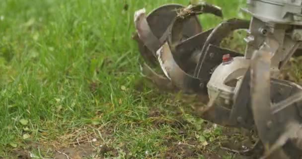 Closeup of hand motor plow blade throwing ground and grass. Cloudy — Stock Video