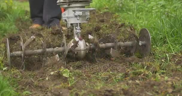 Closeup of hand motor plow blade throwing ground and grass. Cloudy — Stock Video