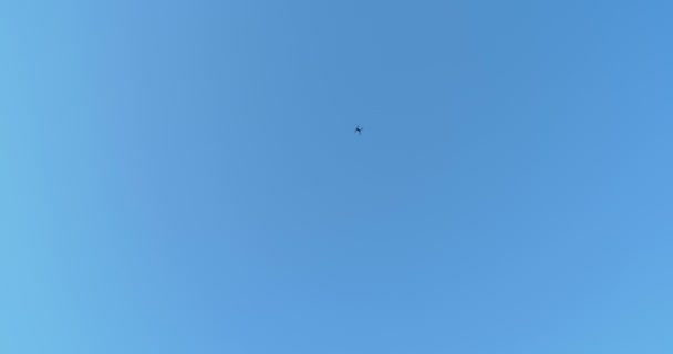 Беспилотник летит на голубом небе. — стоковое видео