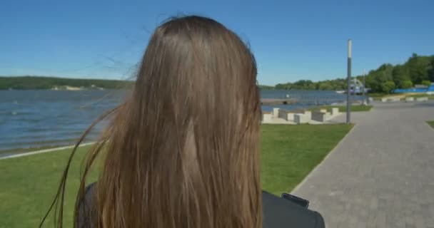 Vista trasera de la mujer elegante caminando en el parque — Vídeos de Stock