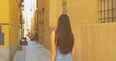 Güneşli bir günde küçük Caddede yürüyen genç turist kadın. Ortaçağdan kalma eski şehir keşfetmek Avrupa'da tatil harcama kız.