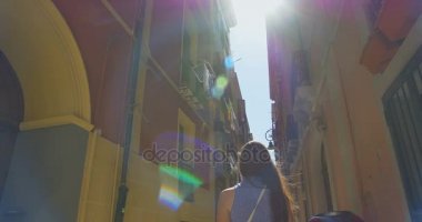 Güneşli bir günde küçük Caddede yürüyen genç turist kadın. Ortaçağdan kalma eski şehir keşfetmek Avrupa'da tatil harcama kız.