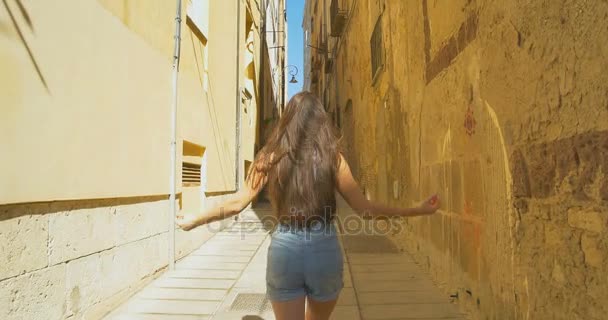 Joven turista mujer caminando por la pequeña calle en un día soleado. Chica pasar vacaciones en Europa, explorar el casco antiguo medieval . — Vídeo de stock