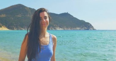 Kumlu plaj boyunca yürüme çekici bayan. Açık mavi su