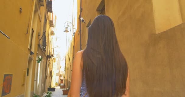 Молодий туристичних жіноча ходити до малих вулиці, в сонячний день. Дівчина витрачає відпустку в Європі, вивчення середньовічного Старого міста. — стокове відео