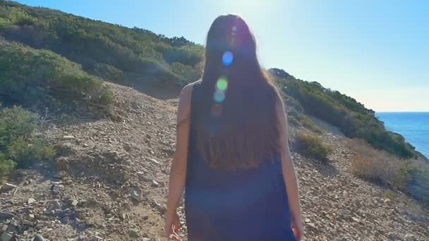 Hermosa joven turista caminando por las montañas del desierto cerca del mar. Movimiento lento . — Vídeos de Stock