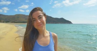 Kumlu plaj boyunca yürüme çekici bayan. Açık mavi su