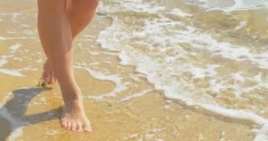 Güzel kadın bacakları, kum plaj going. Suda yürüme.