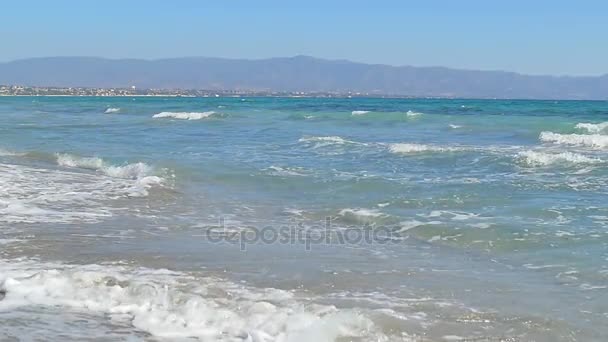 Волны высаживаются на песчаный пляж. Чистая голубая вода. Медленное движение — стоковое видео