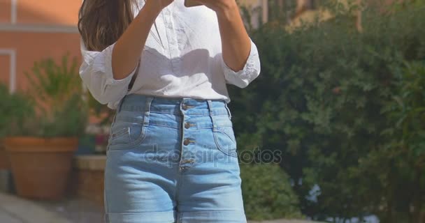 Joven hermosa mujer uso de teléfono inteligente en la ciudad europea — Vídeo de stock