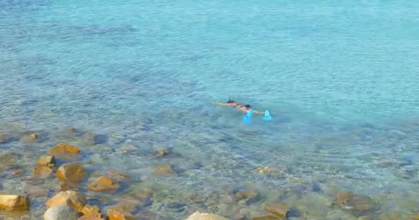 Mujer en Googles pesca submarina, nadando sobre arrecifes cerca de rocas. Día soleado . — Vídeo de stock