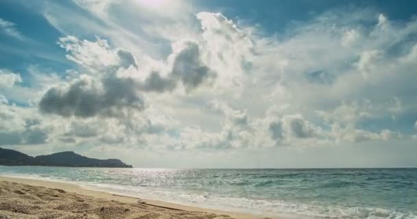 Beach and mountains behind. From the clouds make their way rays of the sun. Timelapse. — Stock Video