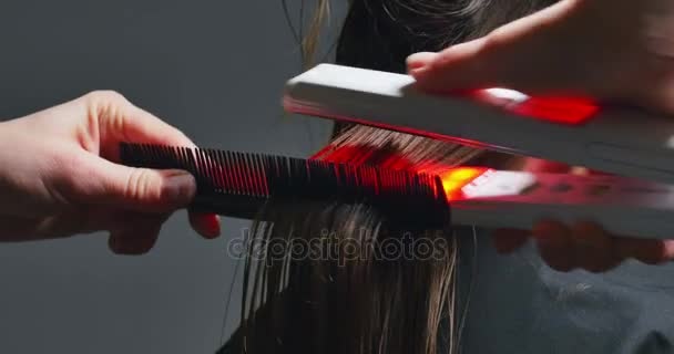 Ręce kobiety zrobić włosy zapisać procedurę. Elektryczny instrument regeneracji włosów z czerwony neon light — Wideo stockowe