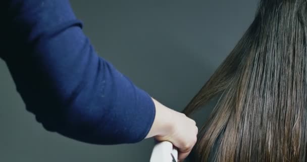 Las mujeres hacen que el pelo ahorre procedimiento. Instrumento eléctrico de regeneración capilar con luz de neón roja — Vídeos de Stock