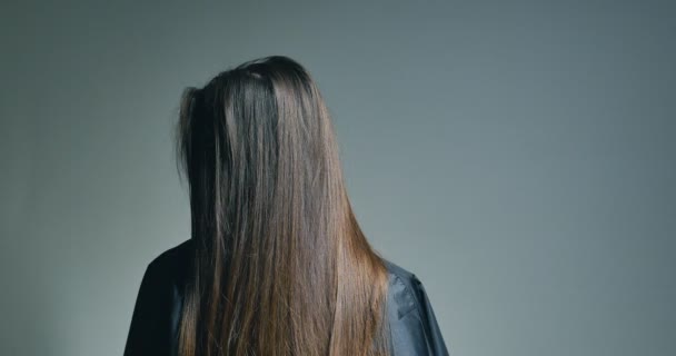 Zadní pohled na bruneta žena hraje s vlasy nad jasné pozadí — Stock video