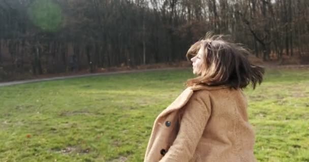 Volg mij, jong vrolijk lachend meisje dat rent en je vraagt haar te volgen in het herfstpark. jonge aantrekkelijke vrouw rennen en glimlachen in de zon stralen — Stockvideo