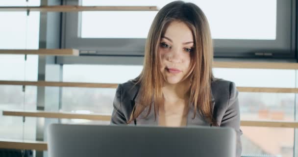 Donna preoccupata che lavora su computer portatile e distoglie lo sguardo pensando risolvere il problema in ufficio. Grave femmina attraente che lavora con notebook — Video Stock