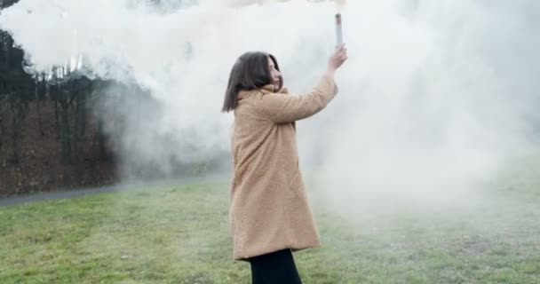 La donna emette un segnale di emergenza con fumo bianco. Hipster bella ragazza con fumo bomba — Video Stock