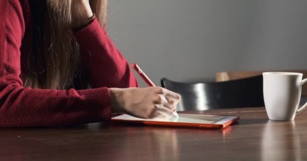 Крупним планом жінка-дизайнер сидить і працює за столом. Сучасна молода жінка малює і використовує ручку з цифровим планшетом. Приваблива дівчина створює цифрові ілюстрації — стокове відео