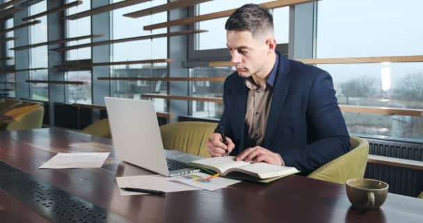 Hombre preocupado trabajando en el ordenador portátil y mirando hacia otro lado pensando en resolver el problema en la oficina. Varón atlético serio trabajando con cuaderno — Vídeos de Stock