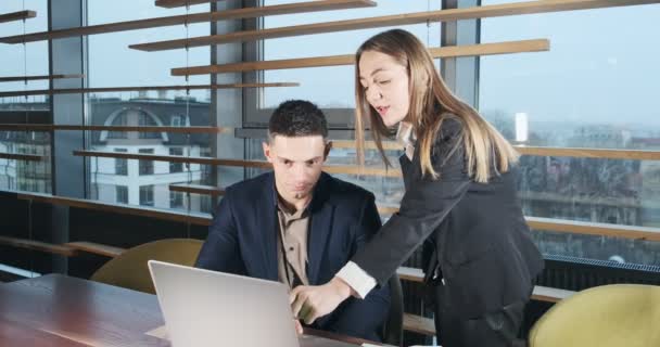 Portret mężczyzny i kobiety omawiających pracę z notatnikiem w jasno oświetlonym nowoczesnym biurze. Zaniepokojona kobieta mówi pracujący mężczyzna z laptopem. Poważni biznesmeni pracujący z notatnikiem — Wideo stockowe