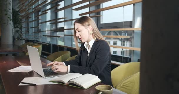 Aggódó nő, aki laptopon dolgozik, és elfordítja a fejét, hogy megoldja a problémát az irodában. Súlyos vonzó nő dolgozik notebook — Stock videók
