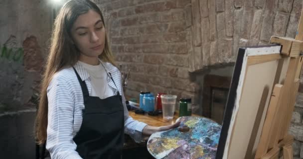 Talented innovative pretty Female Artist Draws with brush on the Canvas. Contemporary young woman painter creating abstract picture. Attractive girl creates modern art painting — 비디오