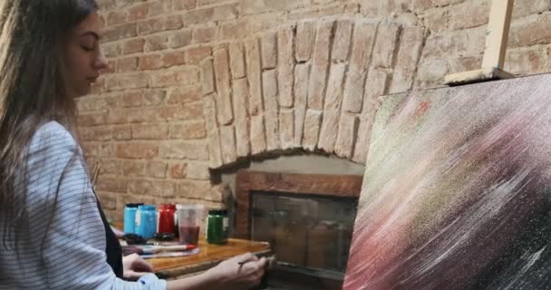 Talangfull innovativ söt kvinnlig konstnär Ritar med borste på duken. Samtida ung kvinna målare skapar abstrakt bild. Attraktiv flicka skapar modern konst målning — Stockvideo