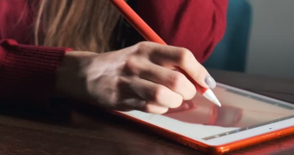 책상에 앉아서 일하는 여성 디자이너를 확대하는 것입니다. 현재 젊은 여성 이 디지털 태블릿으로 펜을 그리고 사용하고 있습니다. 매력적 인 소녀 디지털 일러스트를 만든다 — 비디오