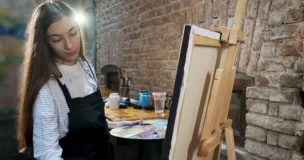 Talentovaný inovativní hezká žena umělec kreslí se štětcem na plátně. Současná mladá žena malířka vytváří abstraktní obraz. Atraktivní dívka vytváří moderní umění malířství — Stock video