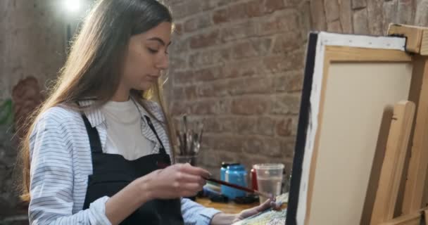 Talentierte innovative hübsche Künstlerin zeichnet mit Pinsel auf die Leinwand. zeitgenössische junge Malerin schafft abstrakte Bilder. attraktives Mädchen schafft moderne Malerei — Stockvideo