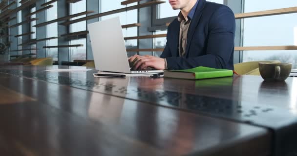 Znepokojený muž pracující na notebooku a přemýšlející o řešení problému v kanceláři. Závažný atletický muž pracující s notebookem — Stock video