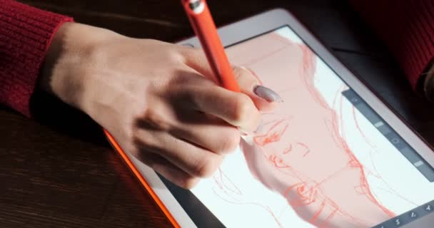 Primer plano diseñador femenino sentado y trabajando en el escritorio. Mujer joven contemporánea dibujando y usando pluma con tableta digital. Chica atractiva crea ilustraciones digitales — Vídeos de Stock