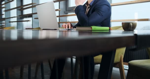 Homme préoccupé travaillant sur ordinateur portable et regardant loin pensant résoudre le problème au bureau. Homme athlétique sérieux travaillant avec ordinateur portable — Video