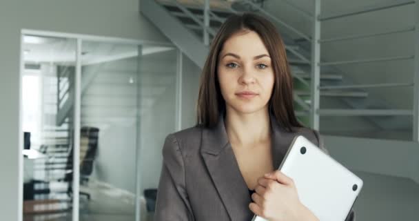 Giovane donna d'affari che cammina nel corridoio dell'ufficio. La femmina attraente seria va a conferenza con notebook e carte — Video Stock